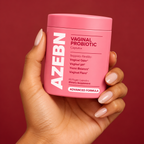 AZEBN women's probiotic capsules jar held in hand against a berry backdrop